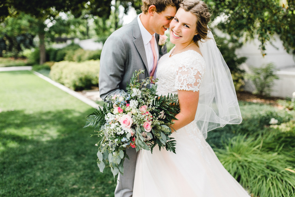 Wedding Couple with Flowers on Grass